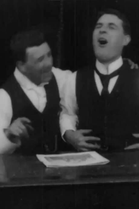    Two men lose it laughing at something in a magazine  